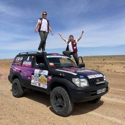 Equipage 101 debout sur le covering du 4x4 Toyota dans le desert Equipage 101 debout sur le covering du 4x4 Toyota dans le desert